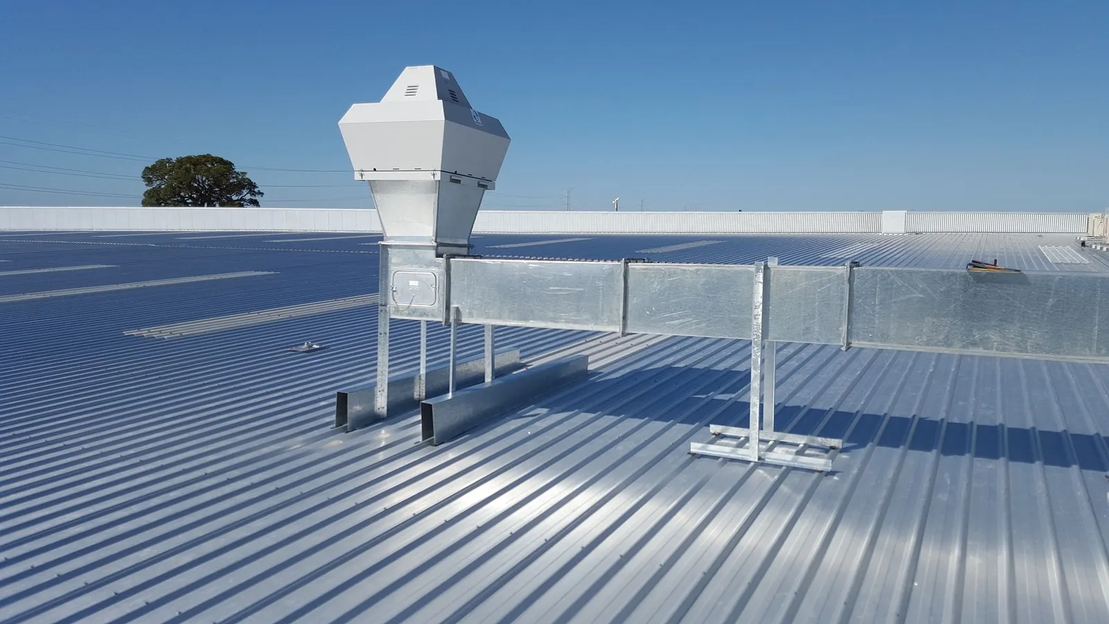 Ductwork and a rooftop vent on a corrugated metal commercial roof